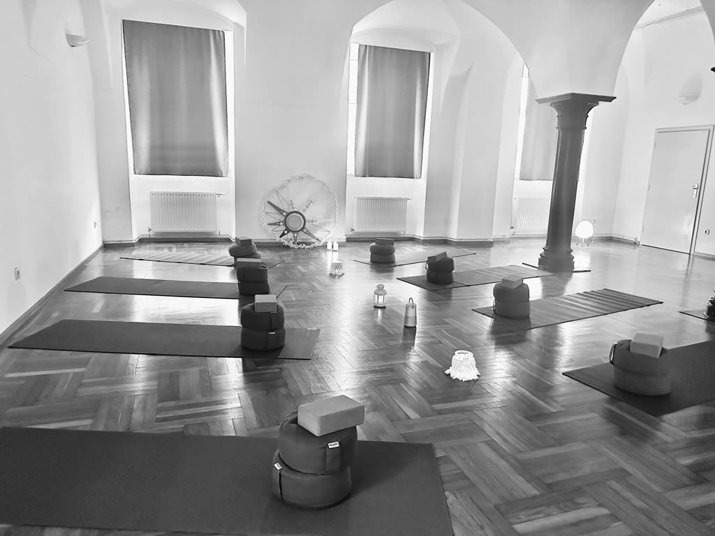 Gewölbesaal mit ausgelegten Yogamatten und Meditationskissen